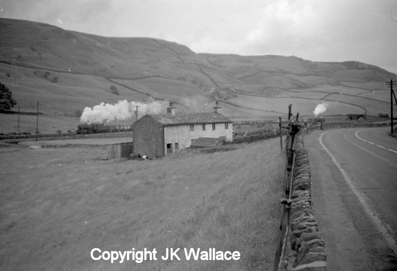 WD Austerity 90412 and banker Crab 42727 ares seen passing Ratten Clough Cottage on the climb to Copy Pit and Rose Grove in the early 1960s.