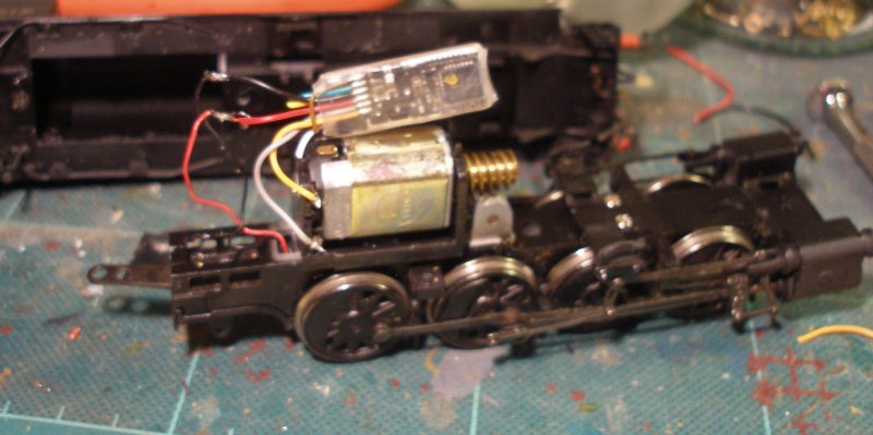 A Zimo MX600R hard wired into a Bachmann WD Austerity 2-8-0 showing it wired in but not yet taped to the top of the motor.