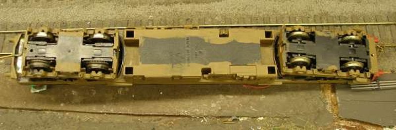 Hornby Class 110 DMU re-motoring project: underside of the original chassis showing Hornby wheels and traction tyres (left) and Ultrascale (right) on the unpowered bogie