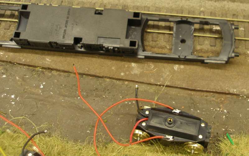 Hornby Class 110 DMU re-motoring project: underside of the replacement chassis showing one of the Black Beetle replacement units. Exisiting bogie stretcher/support modified to take Black Beetle unit