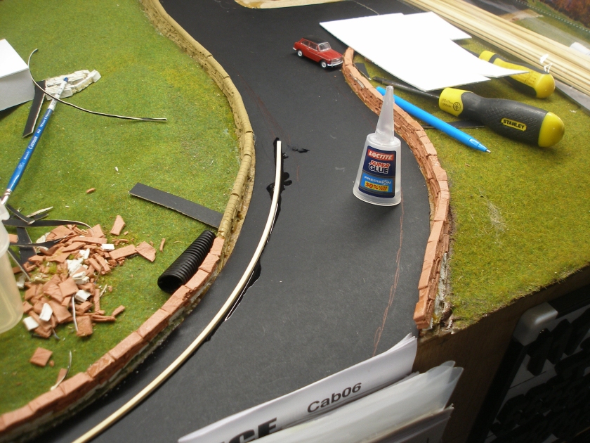 Construction of a 4mm model road: Step 7 First section of kerb laid using Superglue.