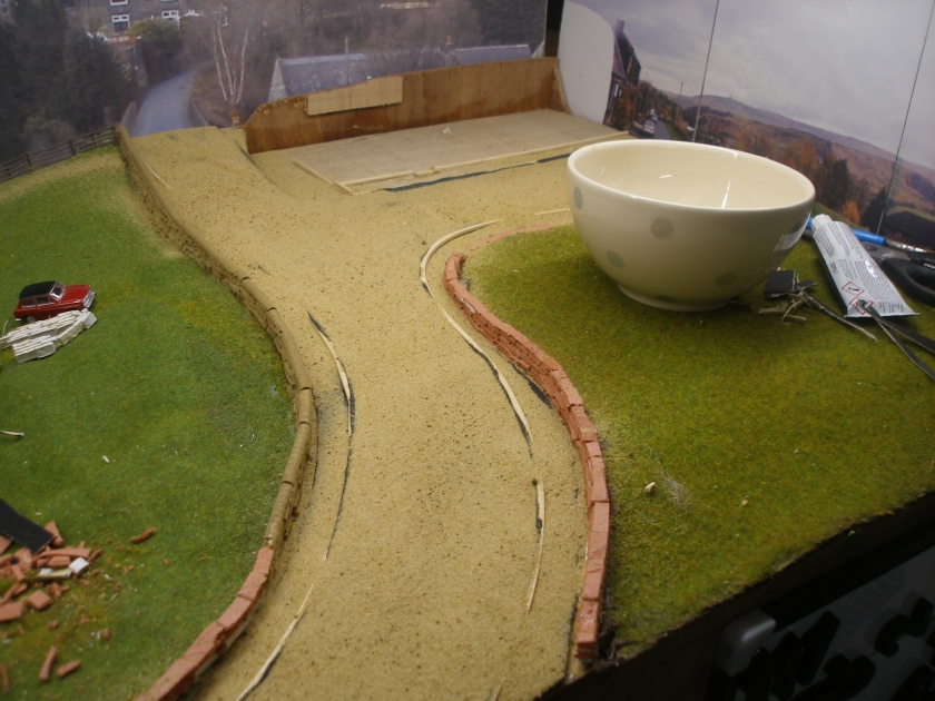 Construction of a 4mm model road: Step 11 Sand is applied to the wet Satin Grey paint.