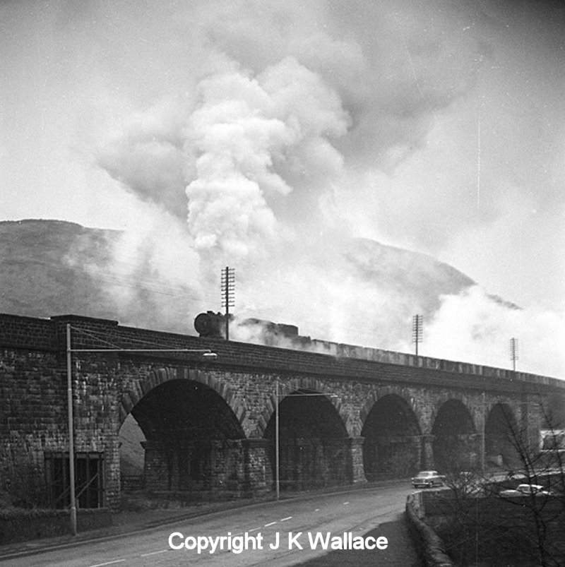 An WD Austerity 2-8-0 heads out of Horsfall Tunnel and onto Lobb Mill Viaduct, Todmorden with a westbound mineral trains c. 1963