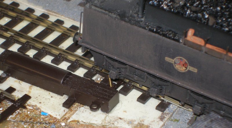 PECO Streamline Bullhead OO scale Code 75 Unifrog point (turnout) showing 10 BA bolt before trimming, and connecting with a tender axlebox as a loco takes the curved route.