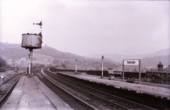 Todmorden Station East 1969 showing the relative position of Hall Royd to Todmorden, it lying right of centre in the distance. The photo clearly shows the Calder Valley line curving gently out of the station in an easterly direction. Hall Royd Road bridge can just be made out between the two gas lamps on the Up platform. The date is further emphasised by the arrival of a 'modern' black-on-white 'Todmorden' running-in board on the Up platform, sitting somewhat uncomfortably in the old frame.