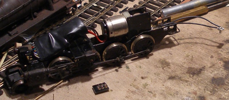 Fitting extra pick-ups to a DJH WD 2-8-0 tender: Two wires are soldered to the pins on the newly formed plug and then fed back through the chassis to the points where the locos own pick-ups are terminated.
