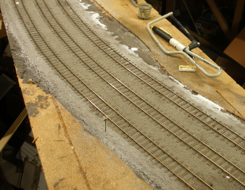Model railway: Creation of a track cess, grassed areas and fencing: ballast shoulder glued with PVA