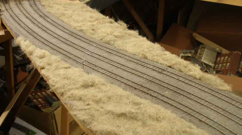 Model railway: Creation of a track cess, grassed areas and fencing: hanging basket grass embankments glued in place