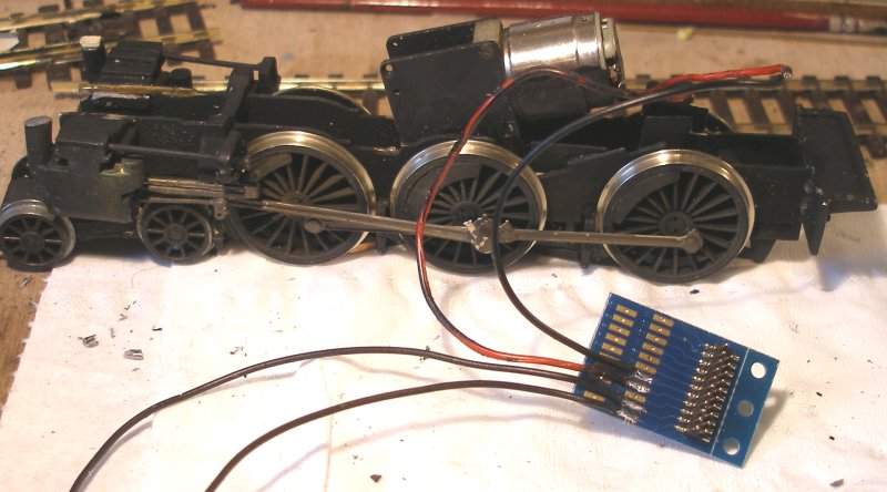 The DJH Caprotti Standard 5 Portsecap-fitted chassis with pick-up wires and motor wires soldered to the adapter. Note the ESU wiring diagram proped up behind.